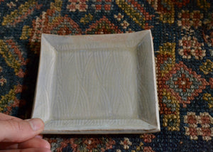 This is a snack plate for your desk, jewelry dish for your bedside table, or landing zone for your favorite mug. Use it for whatever needs a spot to rest. Stamped with a twisted striped pattern and finished with a soft blue glaze. Quittner. Lara Gillett. Hudson Valley.