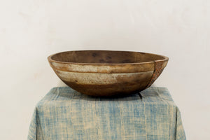a wooden bowl sitting on top of a table 