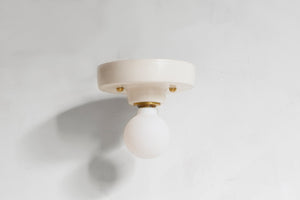 This porcelain surface mount or flush mount-style light is designed to be installed on a ceiling or as a wall sconce, alone or in multiples. Inspired by a 1930s fixture, this light is the perfect solution for a home with lower ceilings or an old house remodel that is seeking to be connected to the past. Designed and made in the Hudson Valley, classic, clean, white, modern, contemporary light, high-end design, luxury design