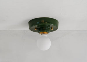 This porcelain surface mount or flush mount-style light is designed to be installed on a ceiling or as a wall sconce, alone or in multiples. Inspired by a 1930s fixture, this light is the perfect solution for a home with lower ceilings or an old house remodel that is seeking to be connected to the past. Designed and made in the Hudson Valley. Green, dark green, forest green, brass, kitchen, bathroom, library