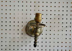 This is an antique nickel-plated silver-colored sconce that was previously repaired with. a copper patch and brass wire, creating a one-of-a-kind piece. Quittner.