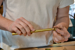 Hand-thrown shade in semi-translucent porcelain glows softly when illuminated, revealing the hand of the maker. Cast porcelain base and brass body. Touch switch. Designed and made in our workshop in the Hudson Valley. Ben shown assembling a Library Lamp in the workshop. Quittner. 