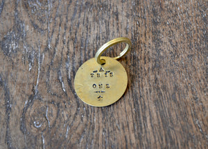 A solid brass key tag hand stamped in our workshop with “This One". Each piece is one-of-a-kind and comes on a brass key ring.