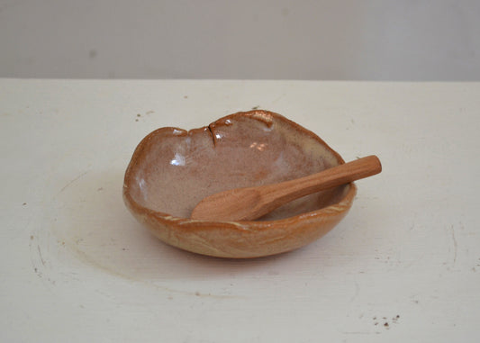 Ceramic bowl with a wooden spoon on a white surface