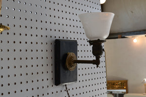 This is an antique brass sconce mounted on a wood backplate that is to be hung on the wall off of a screw or nail. It is operated with a pull-chain, and has a 6 foot long cloth-covered cord.&nbsp;