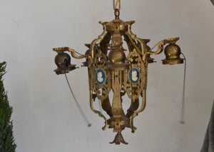 This is a 1920s five-light Brass Chandelier with figural profiles on each of the vertical panels.