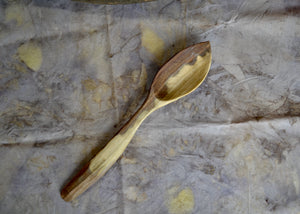 Black Walnut "Leftie" Serving Spoon This piece was carved by Mark Power. He uses hardwoods local to the Hudson Valley sourced from fallen trees and trimmings from local orchards. Mark carves while the wood is green, or still fresh, using edge tools. The pieces are finished with tung oil, which is durable and food safe.
