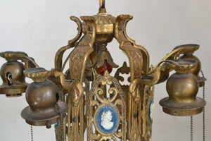 This is a 1920s five-light Brass Chandelier with figural profiles on each of the vertical panels.