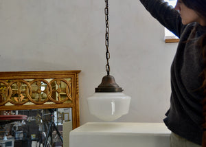 Classic schoolhouse-style pendant light with brass-toned hardware and white glass shade. The patina throughout is outstanding. Newly rewired for modern installation.