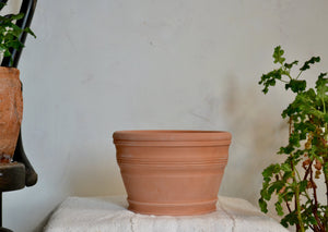 Hand-thrown in terra cotta pot with decorative banding that is ideal for a countertop woody herb like rosemary, sage, or thyme, a seasonal flower like a pansy or marigold, or a trio of bulbs. This pot does not have a drainage hole. Firehouse Pottery Co. Quittner