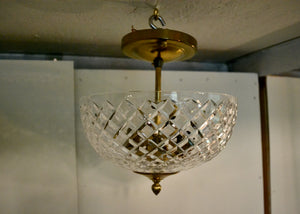 Crystal ceiling light fixture with gold trim hanging from a ceiling. Quittner.