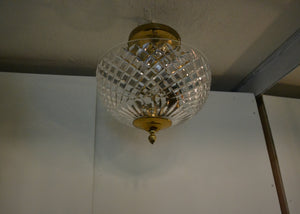 Crystal ceiling light fixture with gold trim hanging from a ceiling. Quittner.