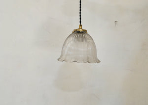 Antique glass Holophane pendant with a bell-shaped form. Cast brass shade holder and brass hardware. Cloth-covered cord. Ideal for over a kitchen or pantry sink, or in a laundry or powder room. Quittner.