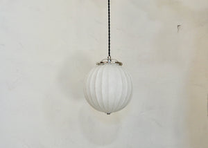 Art Deco-era vintage pendant light featuring a ribbed frosted glass orb and polished nickel details, offering a warm glow. Rewired. Some scuffs and scratches to the glass. Please look carefully at images to confirm condition. Quittner.