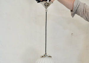 Art Deco-era vintage pendant light featuring a ribbed frosted glass orb and polished nickel details, offering a warm glow. Rewired. Some scuffs and scratches to the glass. Please look carefully at images to confirm condition. Quittner.