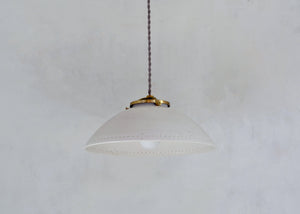 A simple porcelain pendant that speaks volumes. Hand-thrown dome form. Each light is handmade to order from semi-translucent porcelain. Detail along rim as chosen. Quittner. 