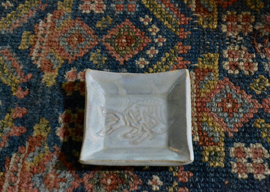 This is a small snack plate for your desk, ring dish for your bedside table, or landing zone for a wet tea bag. Use it for whatever needs a small spot to rest. Stamped with a fish. Quittner. Hudson Valley Made by Lara Gillett. 