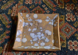 This is a snack plate for your desk, jewelry dish for your bedside table, or landing zone for your favorite mug. Use it for whatever needs a spot to rest. Stamped a pair of paws and finished with a speckled blue glaze. Quittner. Lara Gillett. Hudson Valley.