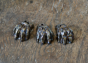 Set of three glazed planter feet with a foundational brown color topped off with an oil slick-like metallic. Pairs well with earth tone glazed planters, reds, and greens. Quittner.