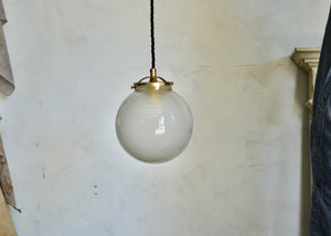 Pendant light featuring a vintage hand-blown frosted glass orb and brass details, offering a warm glow. Rewired. Please look carefully at images to confirm condition. Quittner.