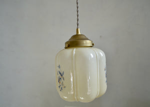 Vintage enclosed neutral glass pendant with blue floral transfer decoration repeating around the sides. Brass shade holder and brass hardware. Cloth-covered cord. Ideal for over an island or breakfast table. Quittner.