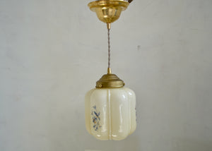 Vintage enclosed neutral glass pendant with blue floral transfer decoration repeating around the sides. Brass shade holder and brass hardware. Cloth-covered cord. Ideal for over an island or breakfast table. Quittner.