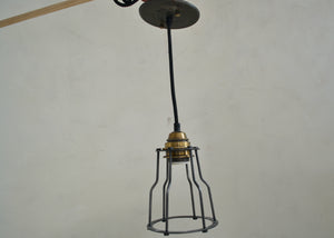 Industrial-style pendant light with metal cage on a plain background