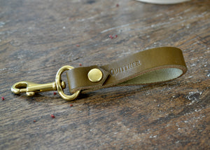 Leather key fob with solid brass hardware and hand stamped with the Quittner logo. Olive.