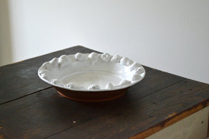 A terra cotta platter with buttermilk white glaze by potter Jessica Weinberg of Firehouse Pottery Co, part of her Summer 2025 body of work inspired by the botanical drawings and painted ceramics of Emily Cole (1843-1913). Quittner.
