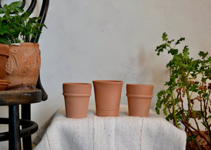 Small planter pots hand-thrown in terra cotta with decorative banding. Each pot has a drainage hole, and is ideal for a countertop herb, seasonal flower like a pansy or marigold, or a single bulb. Firehouse Pottery Co. Athens, NY Quittner Hudson Valley