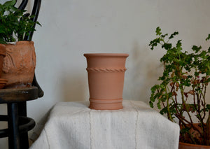 Hand-thrown in terra cotta pot with decorative detailing that is ideal for a woody herb like rosemary, sage, or thyme, a seasonal flower like a pansy or marigold, or a trio of bulbs. It could also be used for a houseplant like a begonia or scented geranium. This pot does not have a drainage hole, so should be used indoors or on a porch with coverage from rain. Firehouse Pottery Co. Quittner