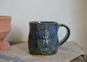 This large 16oz mug was handmade by potter Lara Gillett using slab-building techniques. It features a wave motif. Quittner.