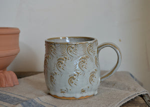 This large 16oz mug was handmade by potter Lara Gillett using slab-building techniques. It features a wave motif. Quittner.