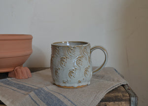 This large 16oz mug was handmade by potter Lara Gillett using slab-building techniques. It features a wave motif. Quittner.