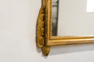 a gold clock sitting on top of a mirror 