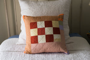 a bed with a red and white striped pillow 