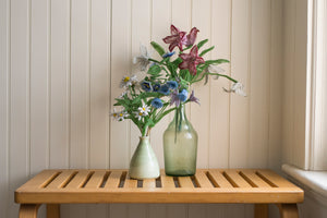 a wooden table topped with a vase of flowers 