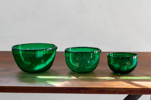 a couple of green vases sitting on top of a wooden table 