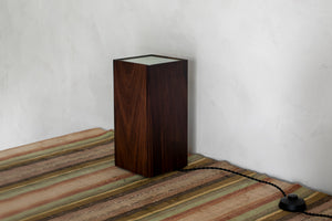 A canister-style floor lamp, or uplight, in black walnut with brass feet that offers a diffused upwards light. Designed and made in the Hudson Valley. Bedroom style, bedside table lamp, uplight, canister lamp, black walnut lamp, foot pedal, luxury home