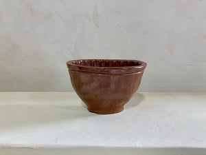 a brown vase sitting on top of a white table 
