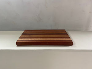 a wooden bench sitting in front of a white wall 