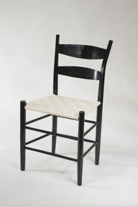 a white chair sitting in front of a chair 